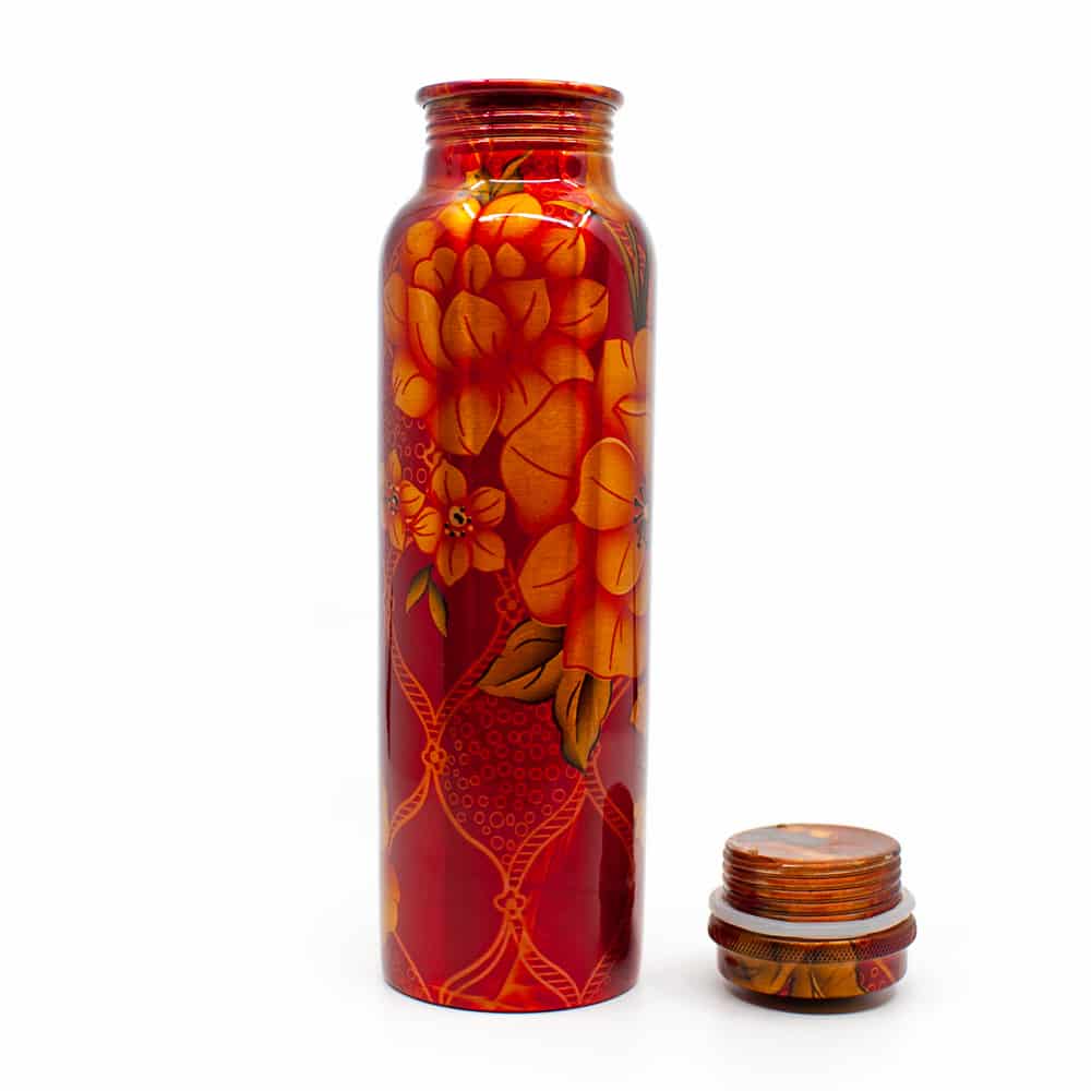 botella de agua de cobre naranja con flores y tapón al lado