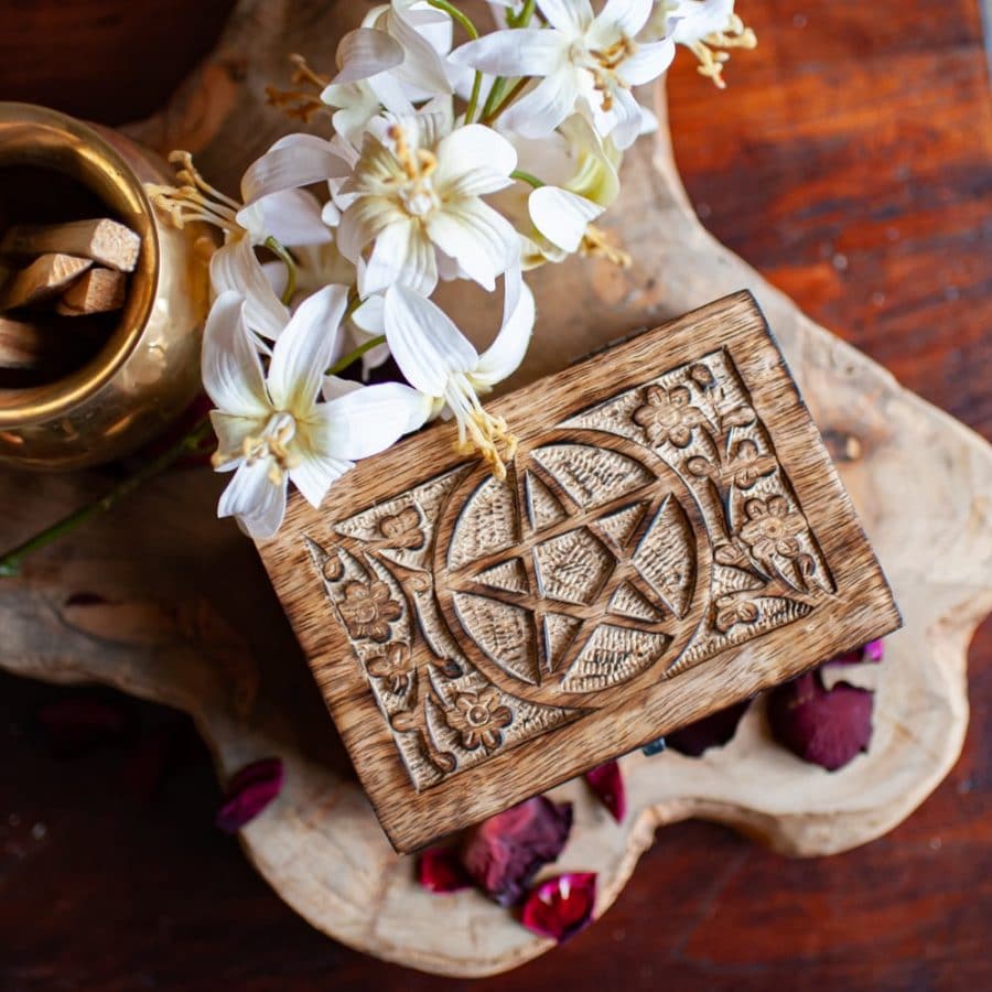 caja con símbolo pentagrama y flores blancas