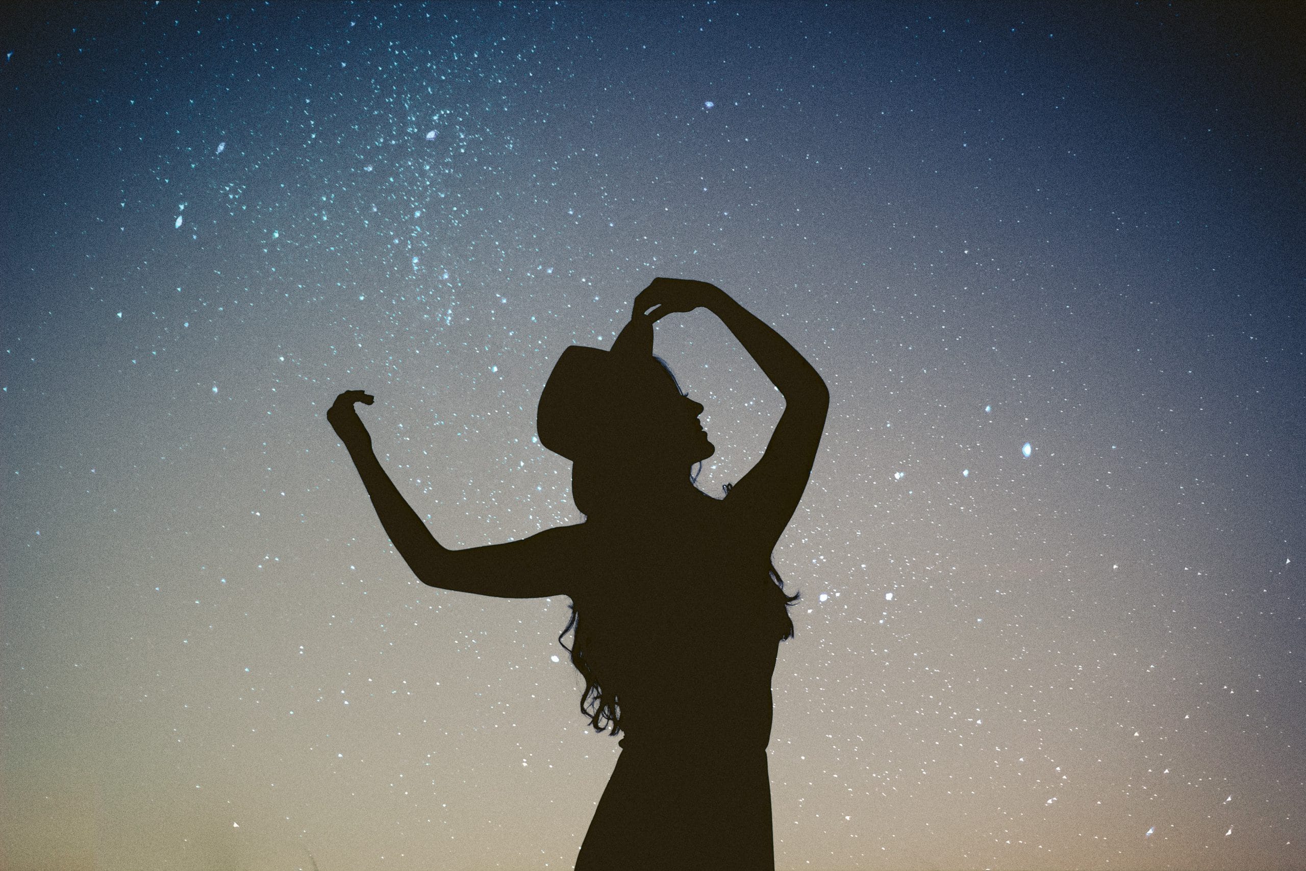 limpieza energética mujer delante de cielo lleno de estrellas